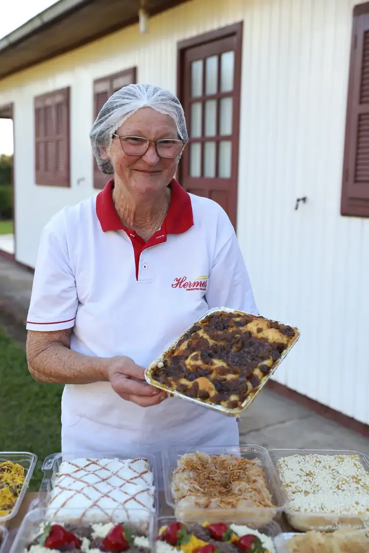 Padeira apresentando uma cuca recém-saída do forno