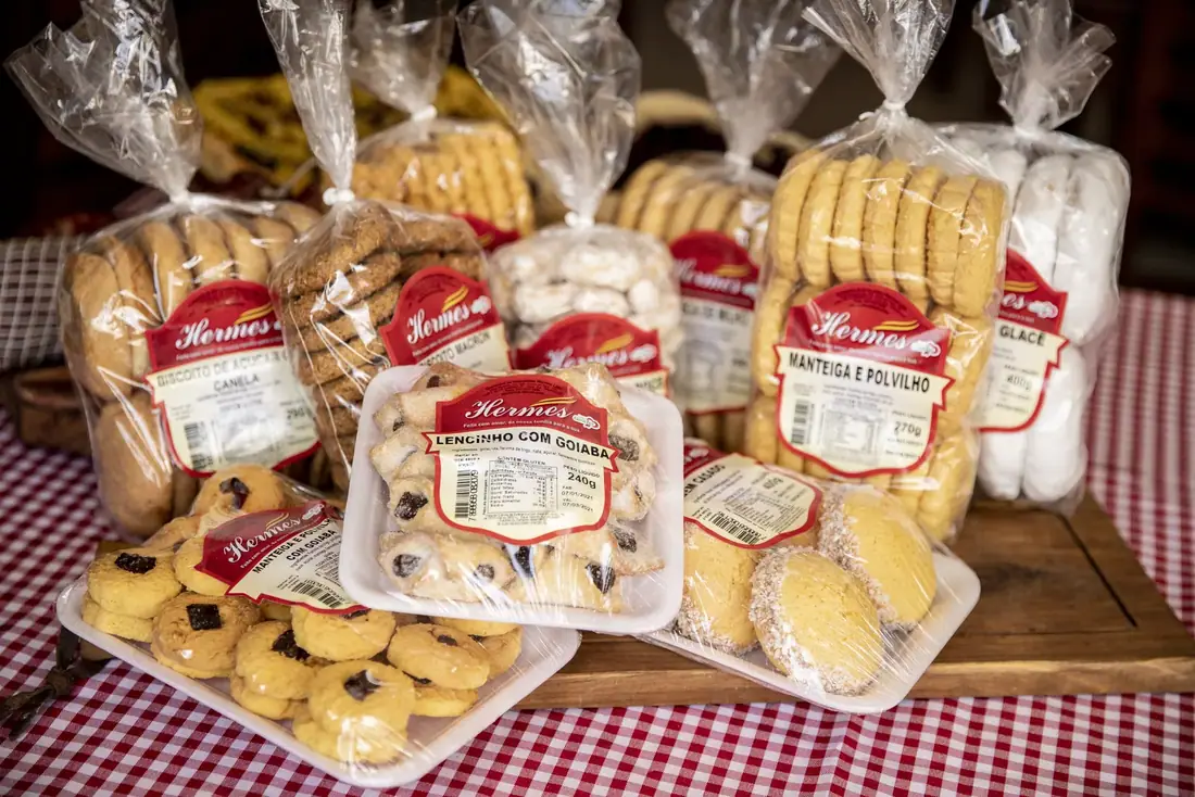 Biscoitos e roscas Hermes embalados sobre toalha xadrez vermelha