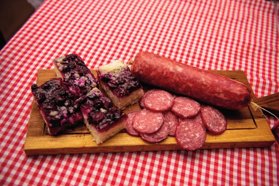Tábua colonial com salame fatiado e cuca de frutas vermelhas